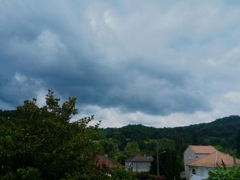 Houses in town against cloudy sky