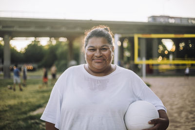 Portrait of smiling oversize woman holding volleyball