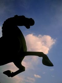 Low angle view of silhouette statue against sky