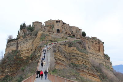 People at historical building against sky