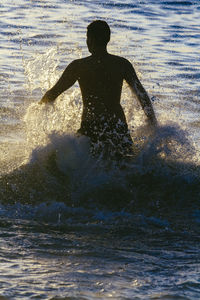 Man splashing water in sea