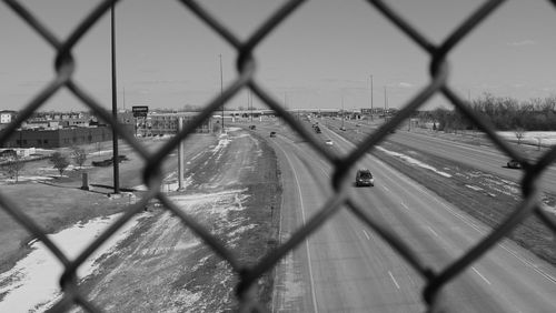 Shadow of chainlink fence against sky