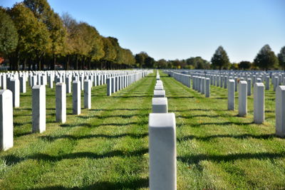 Row of tombstones at fort snelling national cemetery against blue sky