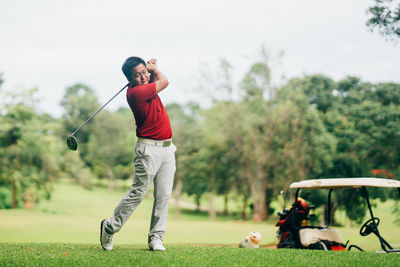 Full length of man on golf course against sky