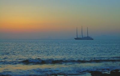 Sailboat sailing on sea against sky during sunset