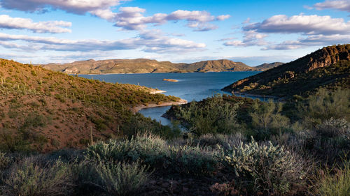 Scenic view of sea and mountains against sky