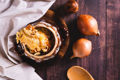 French onion soup with melted cheese and croutons in a pot on the table top view