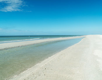 Scenic view of beach against blue sky