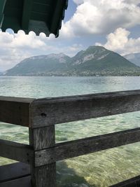 Scenic view of sea by mountains against sky