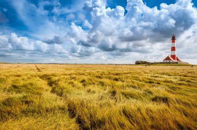 Scenic view of field against cloudy sky