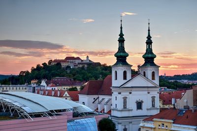 Buildings in city against sky during sunset