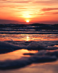 Scenic view of sea against dramatic sky during sunset