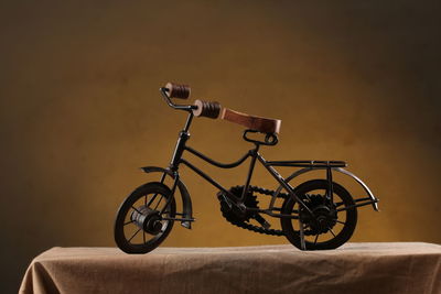 Close-up of toy bicycle against wall