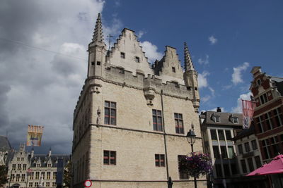 Low angle view of buildings in town against sky