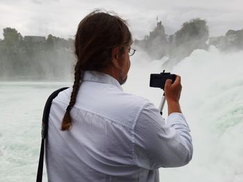 Rear view of woman photographing