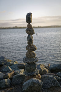 The art of rock balancing with water and sky in the background