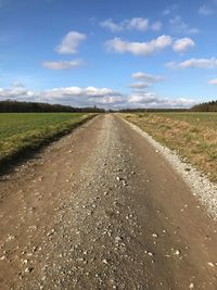 Road amidst field against sky