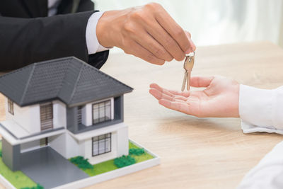 Close-up of hand holding umbrella on table in building