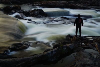 Full length of man standing on rock in water