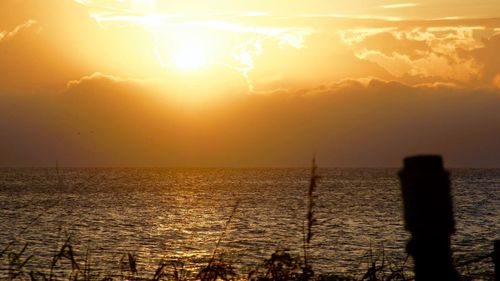 View of calm sea against sunset