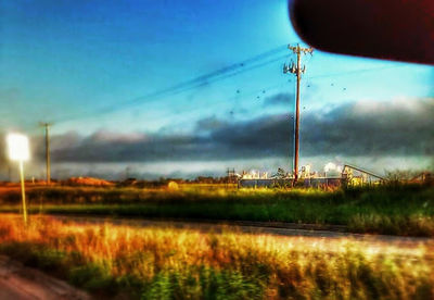 Electricity pylon on field against sky