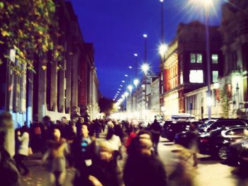 People walking on city street at night