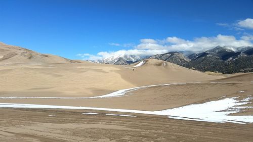 Sand dunes in desert against sky