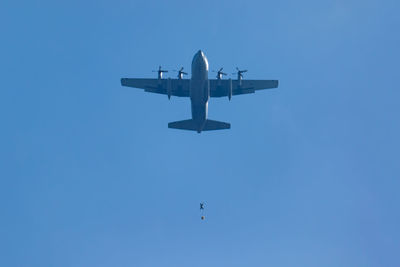 Low angle view of fighter airplane flying against clear sky