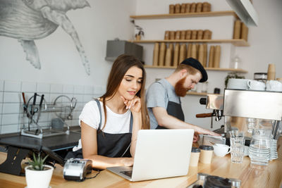 Young woman using laptop at table