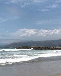 Scenic view of sea and mountains against sky