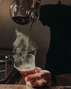 Midsection of man pouring coffee in glass