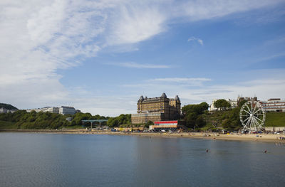 Buildings at waterfront against cloudy sky with scarborough skyline