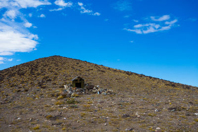 Low angle view of house on mountain against blue sky