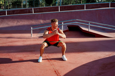 Full length of young woman exercising on court