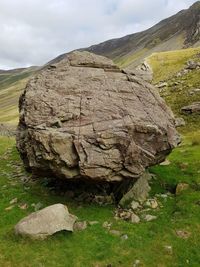 Rock formation on field against sky