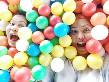 High angle portrait of happy friends playing with colorful balls