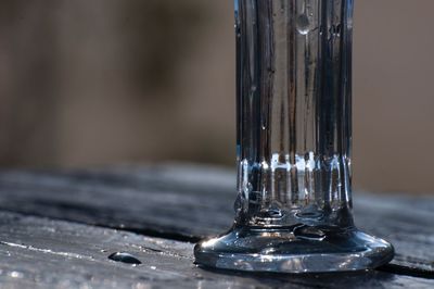Close-up of wet glass on wooden table