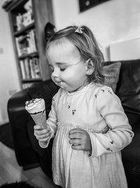 Close-up of cute girl blowing bubbles at home