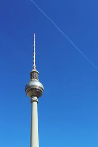 Low angle view of communications tower against blue sky