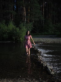 Rear view of woman standing in lake