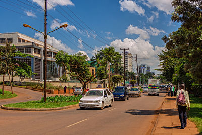 Cars on road against sky in city