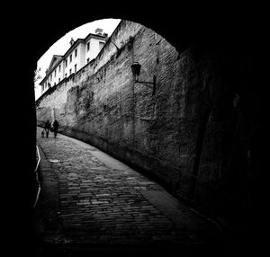 Shadow of person walking on footpath in tunnel