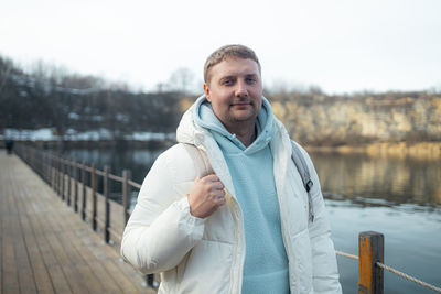 Portrait of man standing against lake