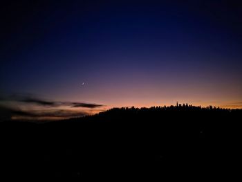 Scenic view of silhouette landscape against sky at night