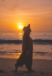 Silhouette woman on beach during sunset