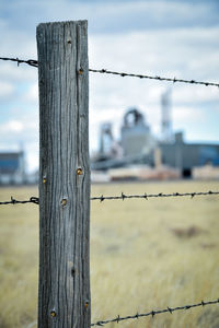 Close-up of barbed wire fence against sky