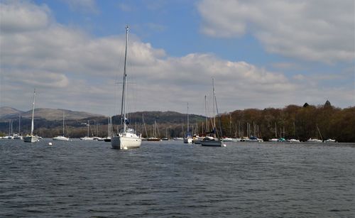 Sailboats sailing on sea against sky