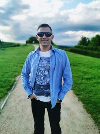 Portrait of young man wearing sunglasses standing on land