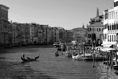 Gondolas in grand canal amidst buildings against clear sky