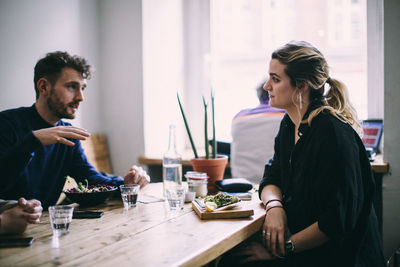 Young couple sitting on table at restaurant